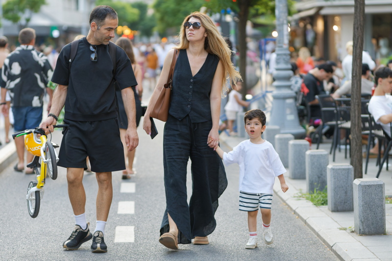 29 - Young family with a little child walking on a pedestrian street